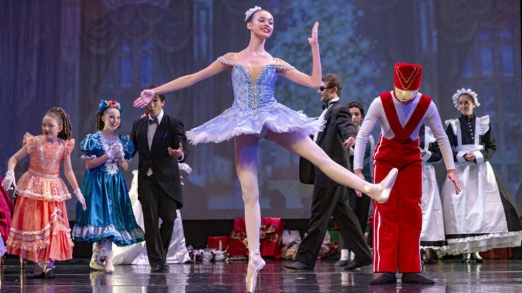 a group of people on a stage with a ballerina.