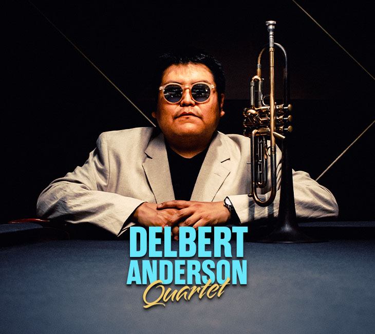 A man in a light suit and sunglasses sits behind a table with a trumpet. Text at the bottom reads "Delbert Anderson Quartet.