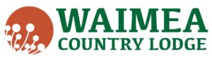 Logo of Waimea Country Lodge featuring the lodge name in green text and a circular brown design with white abstract shapes on the left.